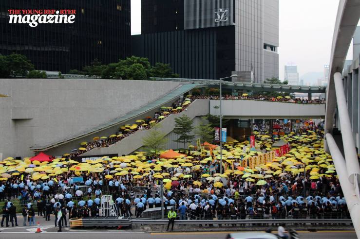 Protestors gather with yellow umbrellas at 5.58pm on Tim Ma Avenue to mark the moment pepper spray was used on crowds last year | Legislative Council Complex | September 28, 2015 | Tanya McGovern