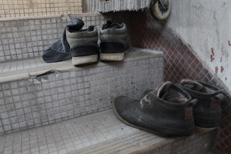 Shoes are left on the staircase to the building rooftop. | Tanya McGovern